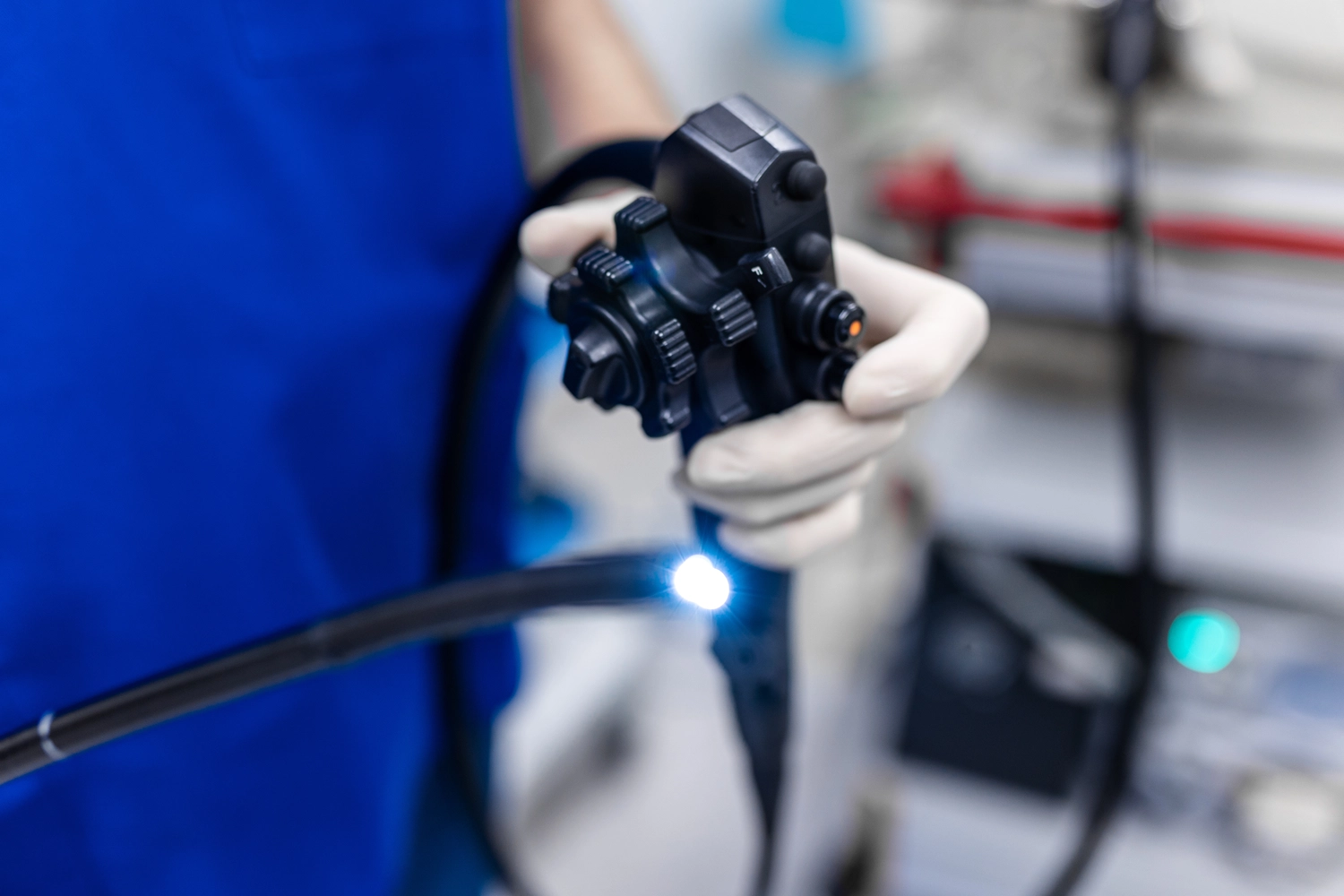 Tierärztliche Praxis für Pferde – In einer klinischen Umgebung hält eine behandschuhte Hand ein medizinisches Endoskop mit einem flexiblen Schlauch und einer Lichtquelle.